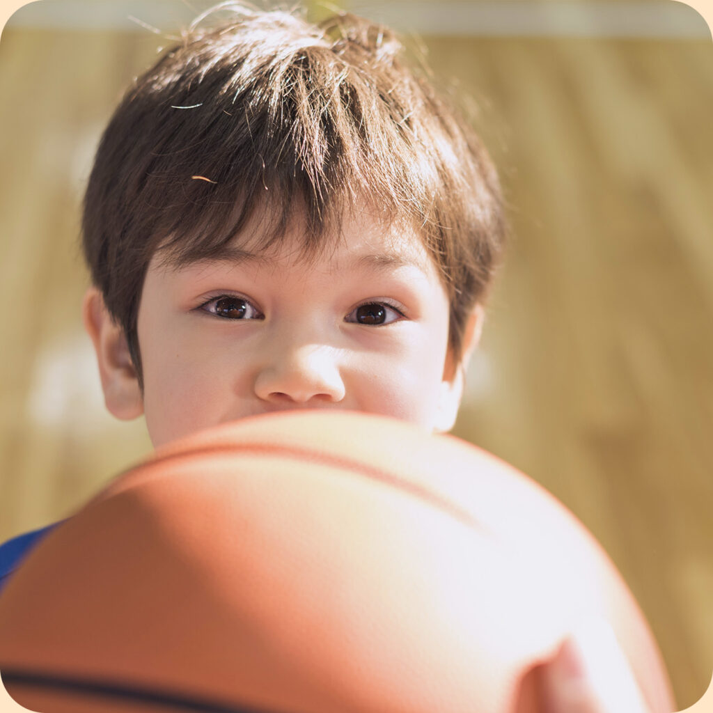 Enfant faisant du Basketball à un cours parascolaire Kiddo Sports