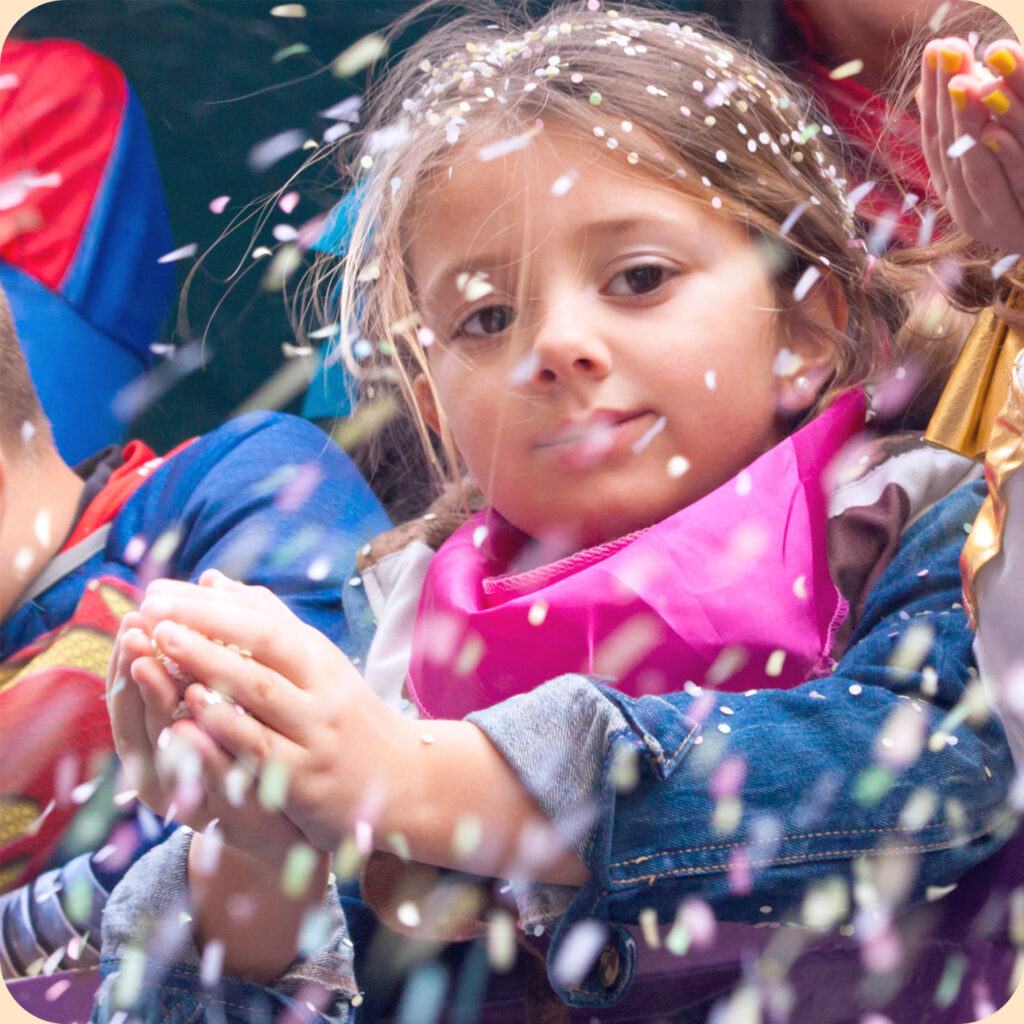 Enfant sur un char de Carnaval lançant des confettis